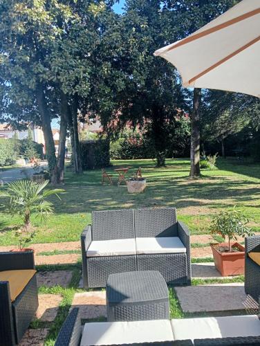 a patio with a table and chairs and an umbrella at Residenza La Dimora ImPerfetta in Salionze