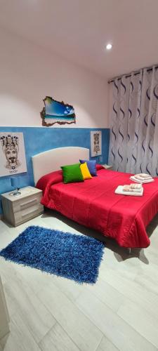 a bedroom with a red bed and a blue rug at Casa Diana in Augusta