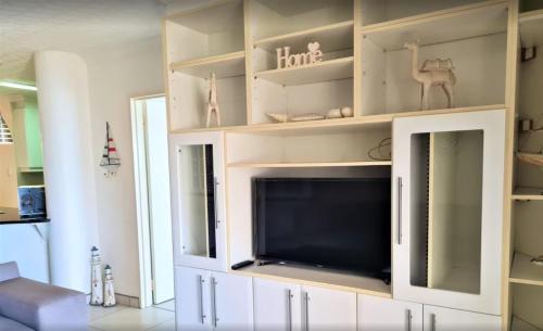 a large white entertainment center with a flat screen tv at Santorini Unit RR in Margate