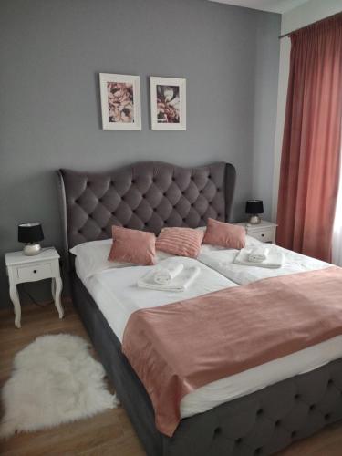 1 dormitorio con 1 cama grande y 2 almohadas en KARINA APARTMAN, en Dunajská Streda