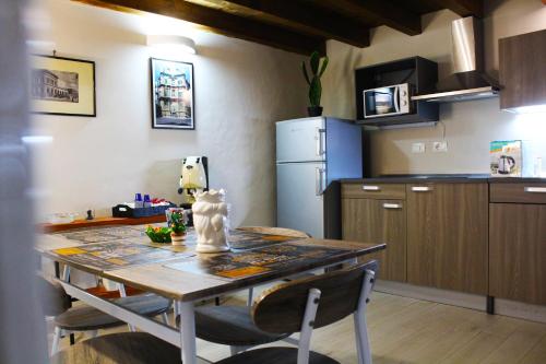 eine Küche mit einem Tisch und einem Kühlschrank in der Unterkunft GDM central apartment Palermo in Palermo