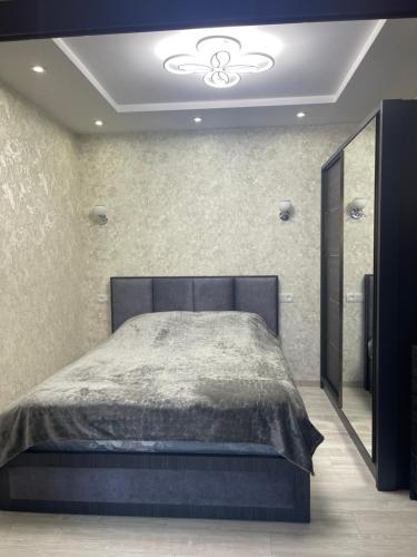 1 dormitorio con 1 cama grande y espejo en Angela’s place, en Vanadzor