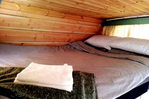 um quarto com uma cama num chalé de madeira em Truck & Pod creative nature retreat. em Bantry