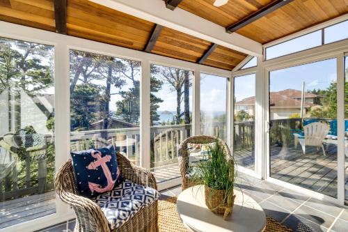 a screened in porch with two chairs and a table at Coastal Tillamook Vacation Rental Ocean Views! in Tillamook