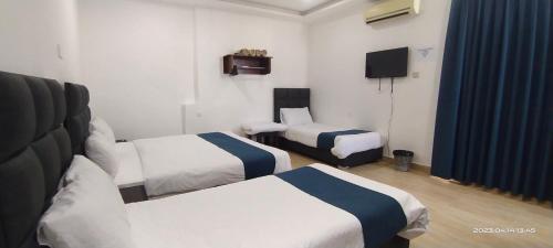 Habitación de hotel con 2 camas y TV en Happy Beach For Studio Rooms Apartment, en Áqaba