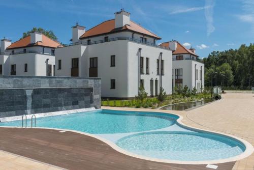 une grande maison avec une piscine en face de celle-ci dans l'établissement 2HomeRent Bosque, à Rogowo