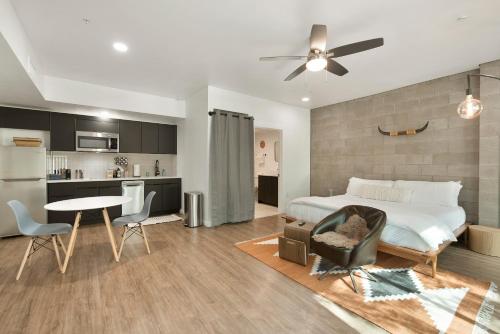 a bedroom with a bed and a table and a kitchen at Tempe Lofty Studios in Tempe
