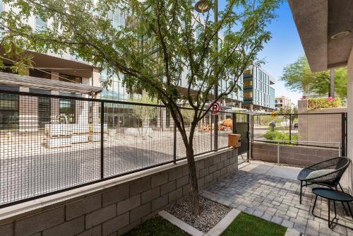 a tree in front of a fence next to a building at Tempe Lofty Studios in Tempe