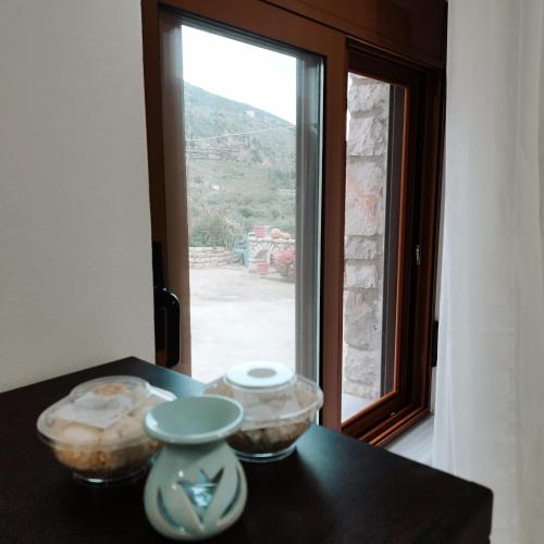 a table with two bowls on it with a window at FarmHouse Qeparo in Qeparo