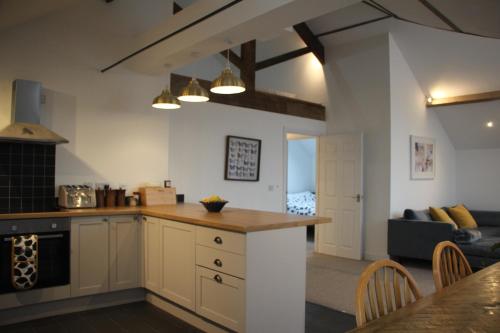 een keuken en een woonkamer met een tafel en een bank bij Clock Tower Apartment in Llandrindod Wells