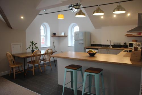 uma cozinha com um balcão e duas mesas e cadeiras em Clock Tower Apartment em Llandrindod Wells