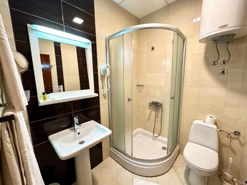 a bathroom with a shower and a sink and a toilet at Hotel Centar in Skopje