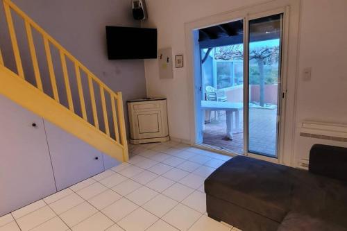 ein Wohnzimmer mit einer Treppe und einer Glasschiebetür in der Unterkunft Charmante Maison de pêcheur in Le Barcarès