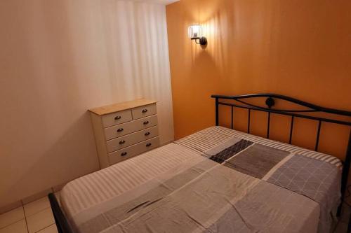 ein kleines Schlafzimmer mit einem Bett und einer Kommode in der Unterkunft Charmante Maison de pêcheur in Le Barcarès
