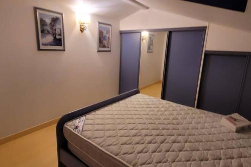 ein Schlafzimmer mit einem Bett in einem Zimmer in der Unterkunft Charmante Maison de pêcheur in Le Barcarès