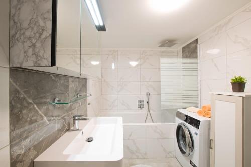 a bathroom with a sink and a washing machine at Vila Residence Leo in Mariánské Lázně