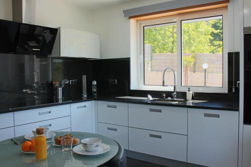 a kitchen with white cabinets and a table and a window at Exclusiva casa con piscina en Gondomar in Gondomar