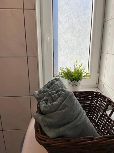 een mand met een deken in een badkamer met een raam bij Bärsta BnB in Kolbäck