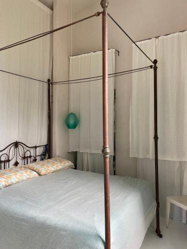 a bedroom with a canopy bed with white sheets at Villa Eletta, Capri in Capri