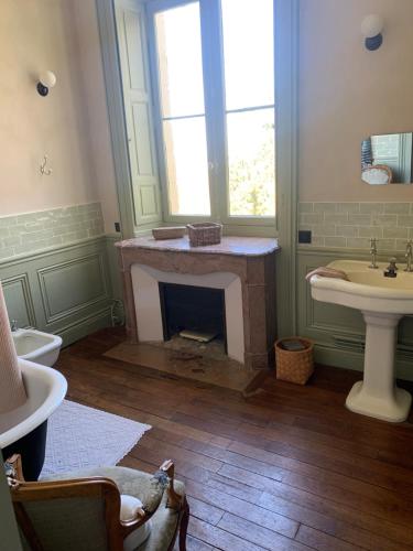 baño con chimenea y lavamanos en Suite privée rose au Château de la Franceule, en Janzé