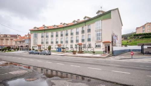 a large building on the side of a street at Piso Av Galicia playa in Finisterre