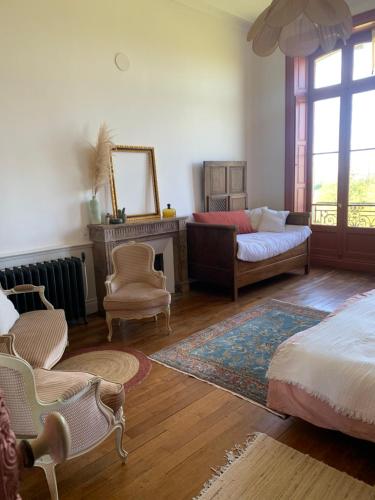 sala de estar con cama y sofá en Suite privée rose au Château de la Franceule, en Janzé
