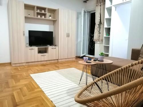 - un salon avec une table, des chaises et une télévision dans l'établissement MB apartman, à Obrenovac