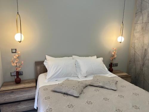 a white bed with two pillows and two towels on it at Psaropoula's Hidden Gem in Rhodes Town