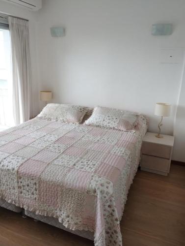 a bedroom with a bed with a pink and white blanket at Departamento Zona Puerto De Olivos in Olivos