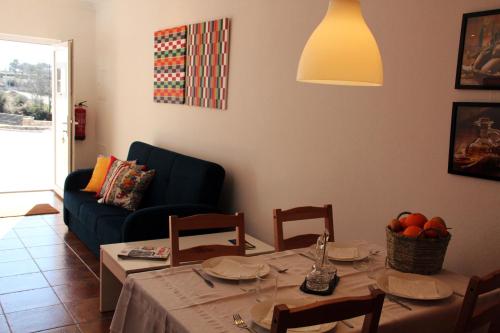 a living room with a table and a blue couch at Eira Velha in Portalegre