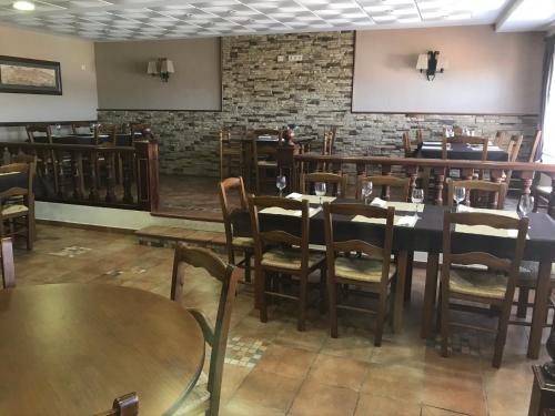 una sala da pranzo con tavoli, sedie e un muro di mattoni di LA CASA DEL SECRETARIO a Sotos