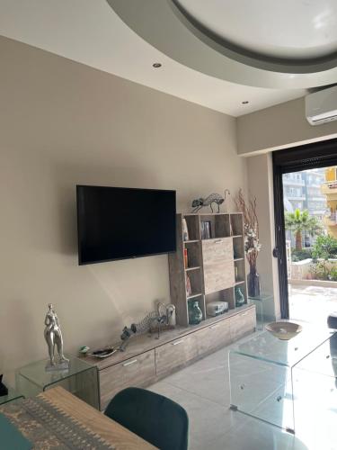 ein Wohnzimmer mit einem Flachbild-TV an der Wand in der Unterkunft Psaropoula's Hidden Gem in Rhodos (Stadt)