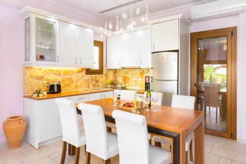 a kitchen with a wooden table and white cabinets at Villa Uliana Kassandra Greece in Afitos