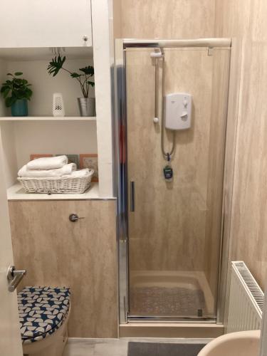 a shower with a glass door in a bathroom at Hillview, Ground floor apartment, Largs in Largs