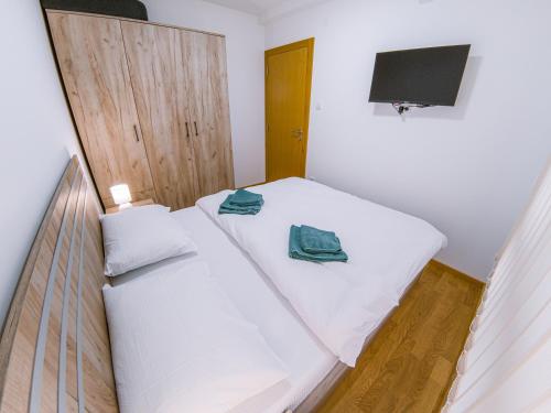 a small bedroom with two beds and a television at Apartman Bellini 2 in Soko Banja