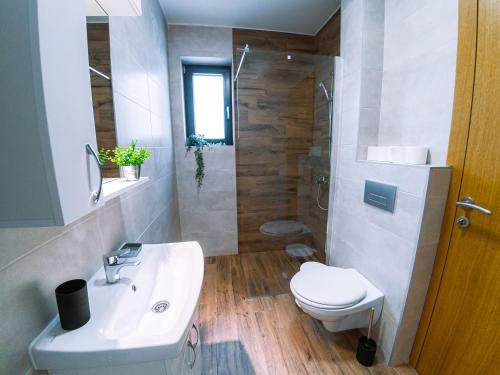 a bathroom with a toilet and a sink and a shower at Apartman Bellini 2 in Soko Banja