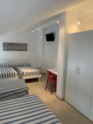 a room with two beds and a table with a desk at Cà Dei Barcaroli in Mestre
