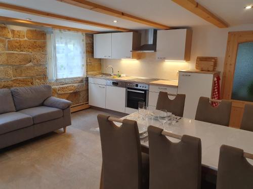 a kitchen and dining room with a table and a couch at Ferienhaus Bildhauer Thiele in Ottendorf