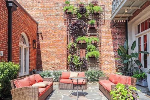 a patio with chairs and a table in front of a brick building at Roami at Factors Row in New Orleans