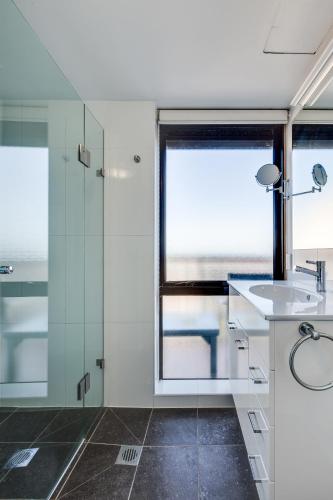 a bathroom with a glass shower and a sink at Hillcrest Apartment Hotel (formerly Central Hillcrest Apartments) in Brisbane