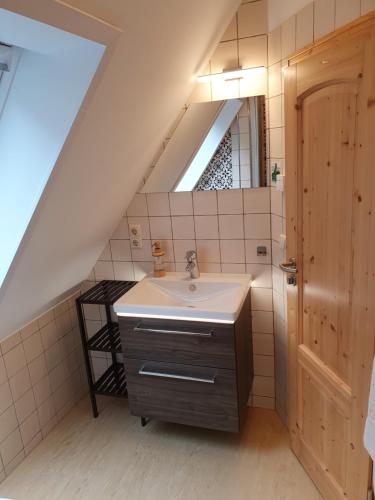 a bathroom with a sink in a attic at Ferienhaus Bildhauer Thiele in Ottendorf