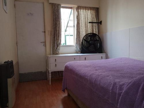 1 dormitorio con cama morada y ventana en Corazón Malbec en Mendoza