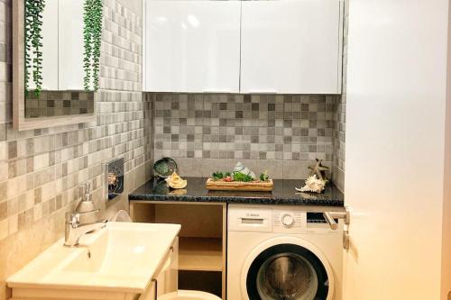 uma cozinha com uma máquina de lavar roupa e um lavatório em Vivenda Espaçosa e Luminosa em Quelfes