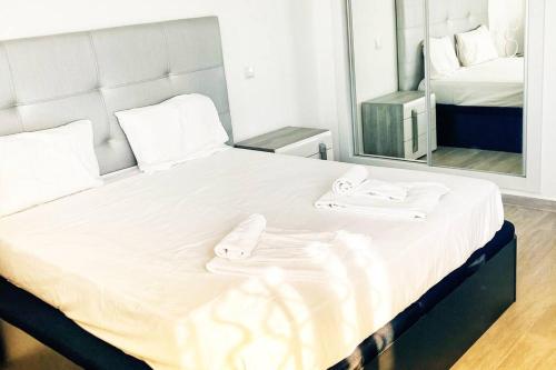 uma grande cama branca com duas toalhas em Vivenda Espaçosa e Luminosa em Quelfes