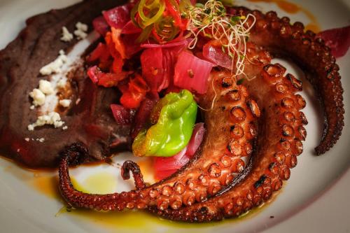 a plate of food with a sausage and vegetables at Hotel Rancho Encantado in Bacalar