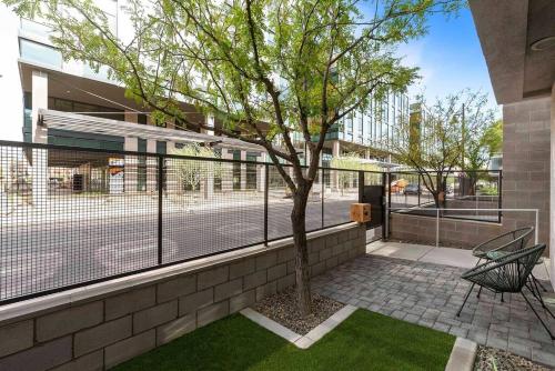a tree in a courtyard with a tennis court at Tempe Lofty Studios in Tempe