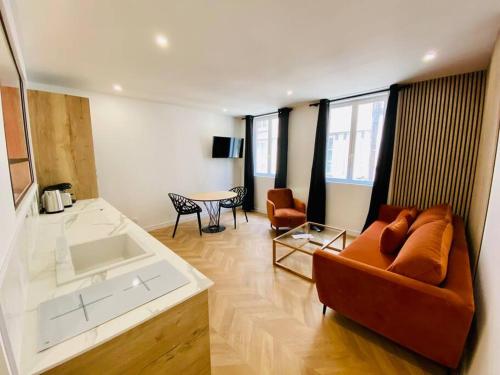 salon z kanapą i stołem w obiekcie L’intemporel w Rouen