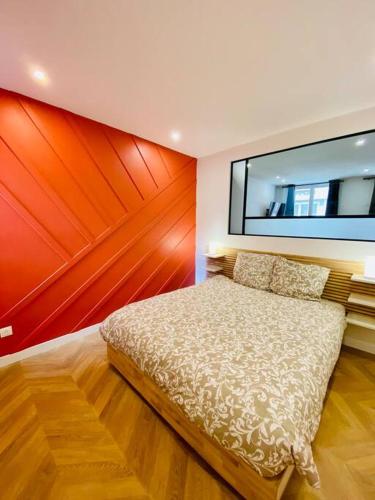 une chambre avec un lit et une télévision au mur dans l'établissement L’intemporel, à Rouen