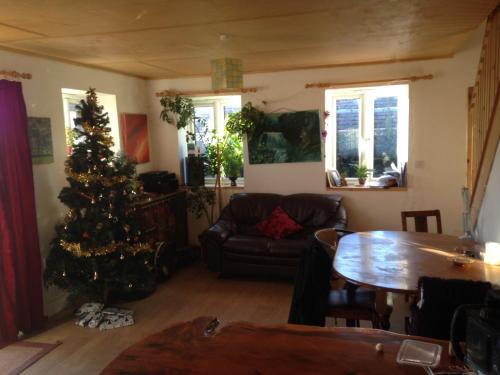 a living room with a christmas tree and a table at Apple tree House in Saltdean