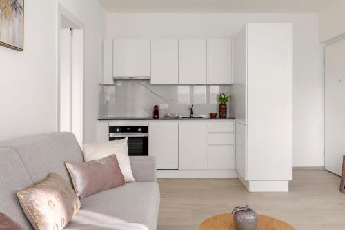 a living room with a couch and a kitchen at Lugano Superior Suites - Free Parking in Lugano